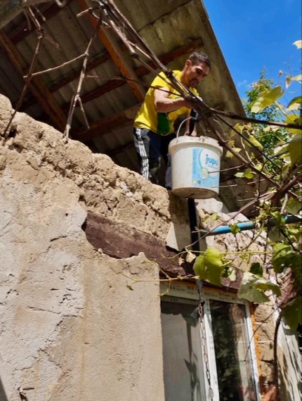 A person standing on a roof with a bucket of water AI-generated content may be incorrect.