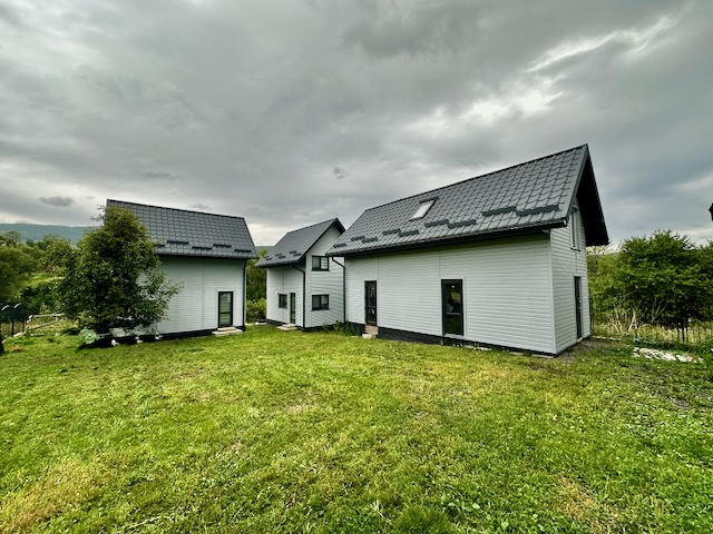 A couple of houses in a grassy area

AI-generated content may be incorrect.