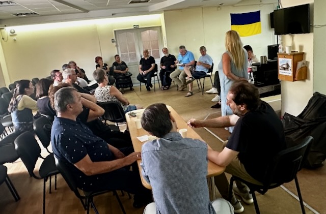 A group of people sitting around a table

AI-generated content may be incorrect.