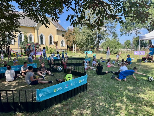 A group of people sitting in a grass field

AI-generated content may be incorrect.