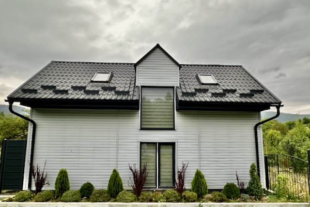 A house with a black roof

AI-generated content may be incorrect.