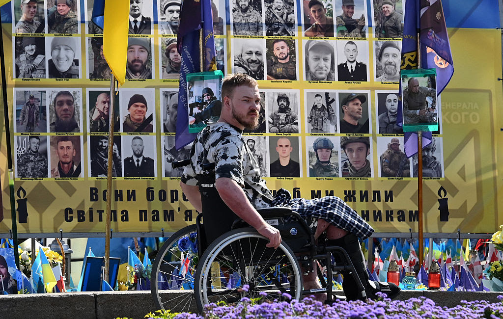 A person in a wheelchair in front of a wall of photos

AI-generated content may be incorrect.