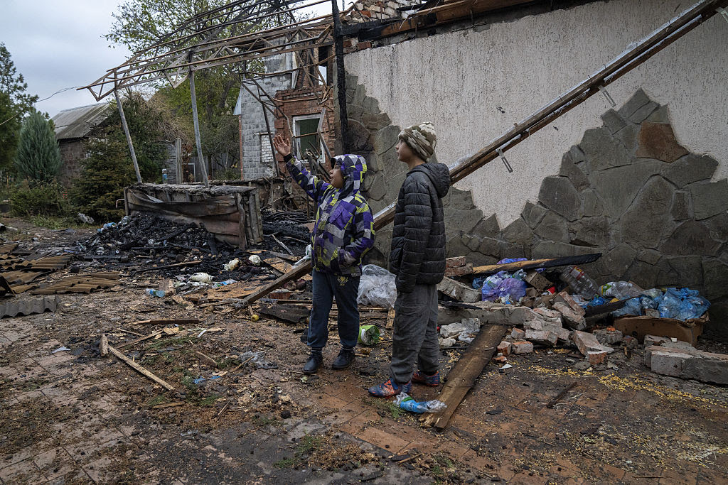 A couple of men standing next to a destroyed building

AI-generated content may be incorrect.