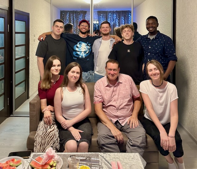 A group of people posing for a photo AI-generated content may be incorrect.