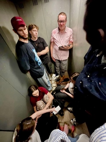 A group of people standing in an elevator AI-generated content may be incorrect.