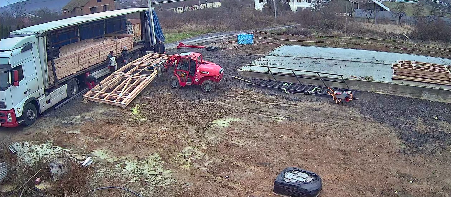 A red tractor pulling a wooden frame

AI-generated content may be incorrect.