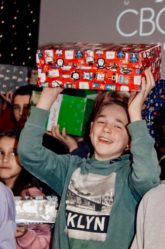 A child holding a box above his head AI-generated content may be incorrect.