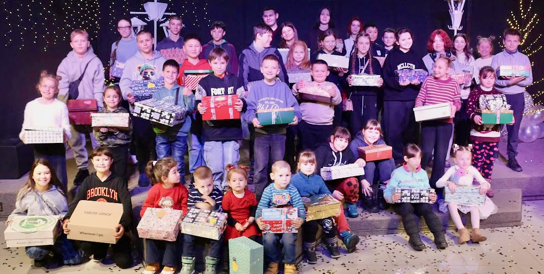 A group of children holding boxes AI-generated content may be incorrect.