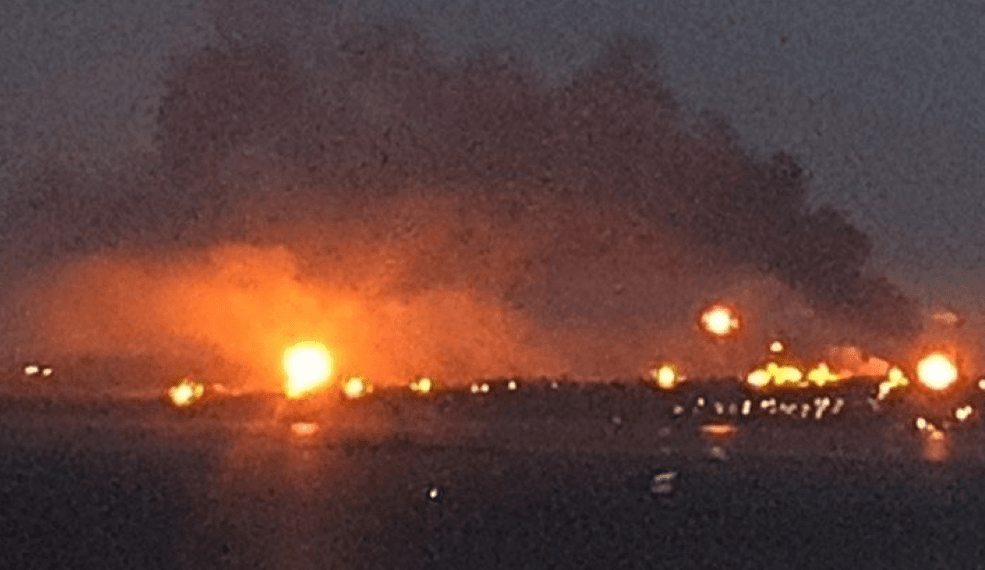Three bright fires in the distance under a night sky